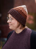 Person wearing a patterned knit hat and vest outdoors