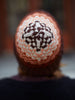 Person wearing a knitted hat with a pattern, blurred background